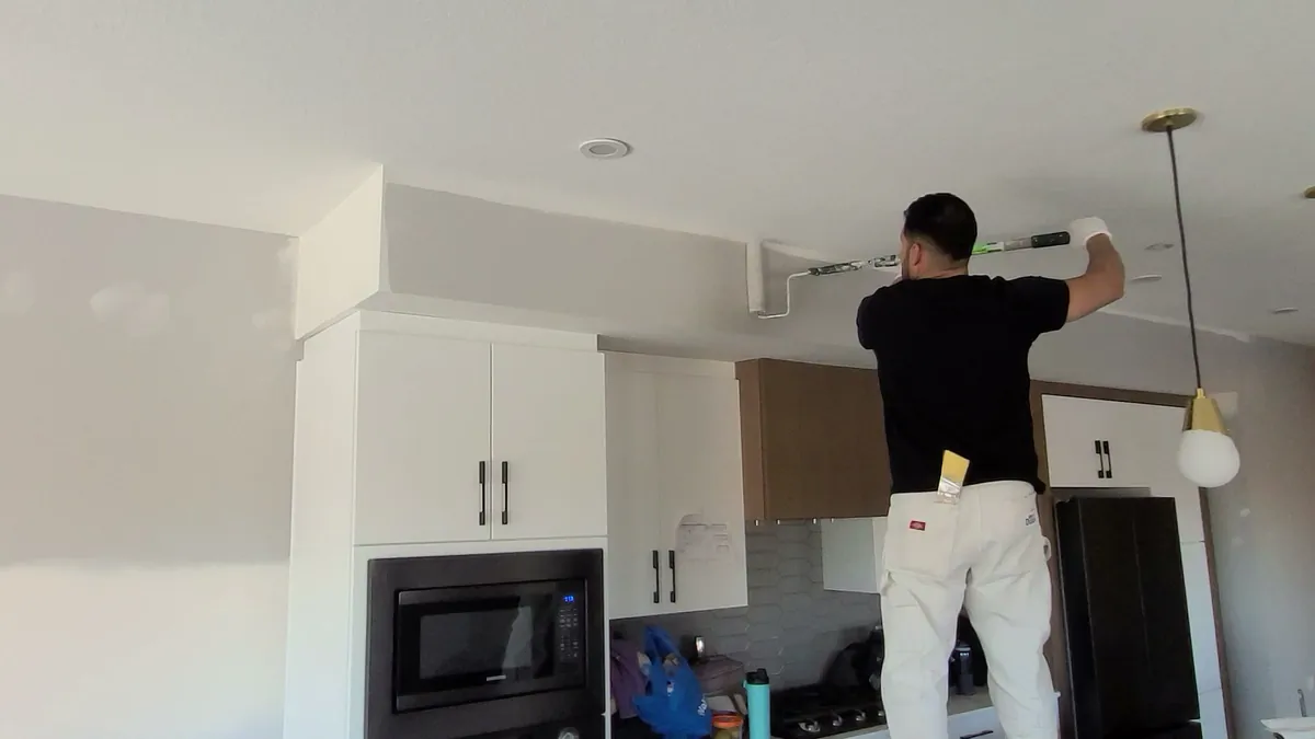 Carlo of the Alpine crew cutting in a bulkhead in a custom kitchen, Windermere