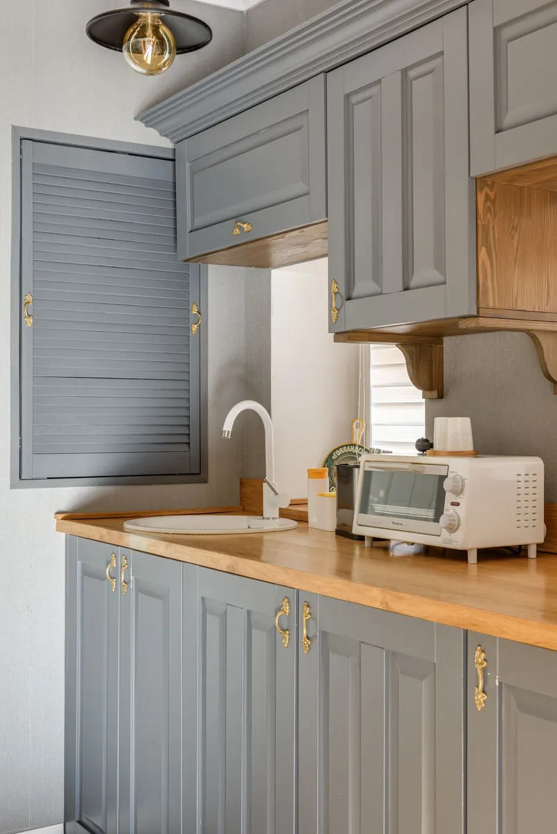 Refinished grey kitchen cabinets with brass hardware