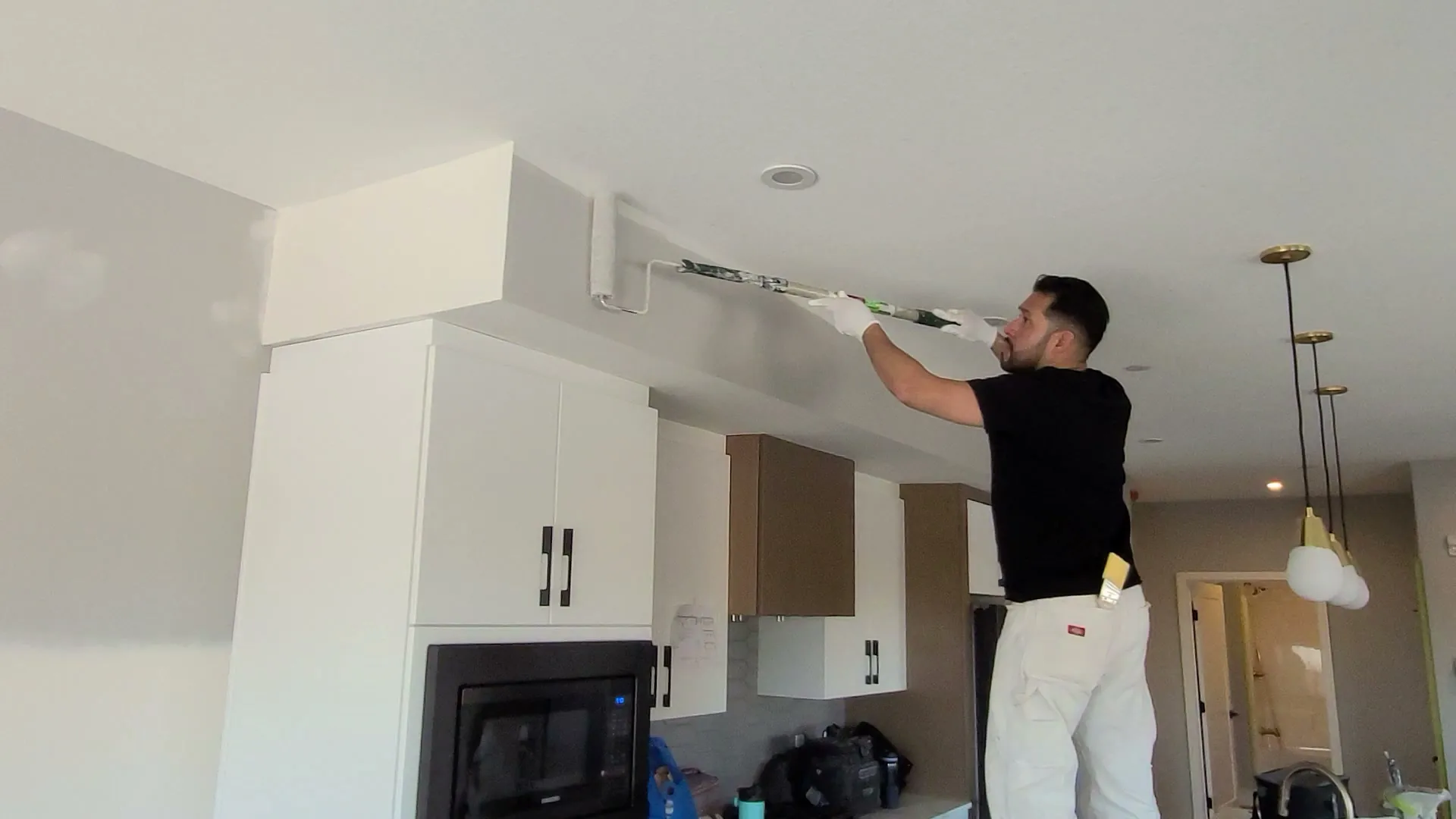 Carlo of the Alpine crew cutting in a bulkhead line in a finished custom kitchen, Windermere